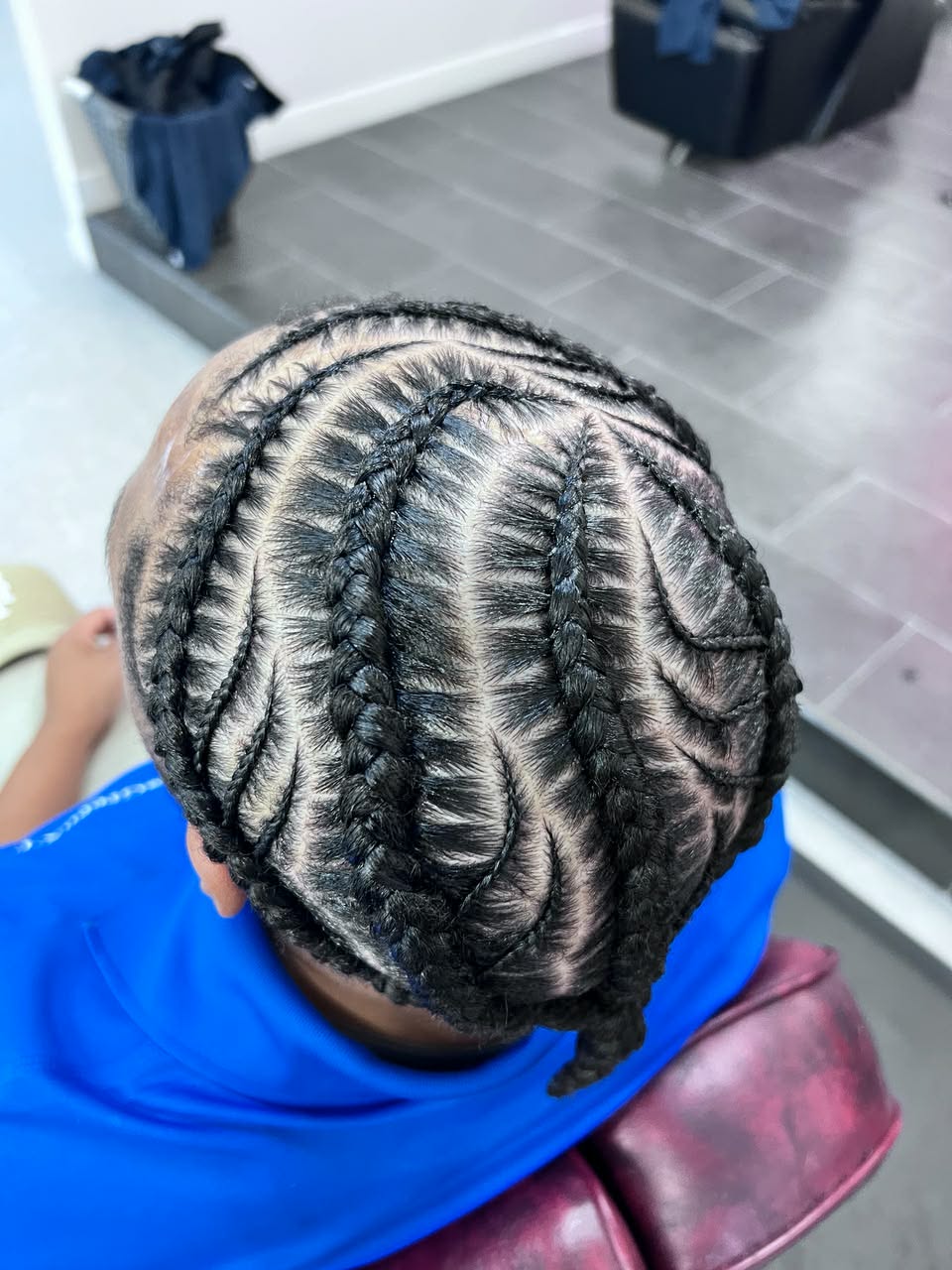 Curved freestyle cornrows on a young client