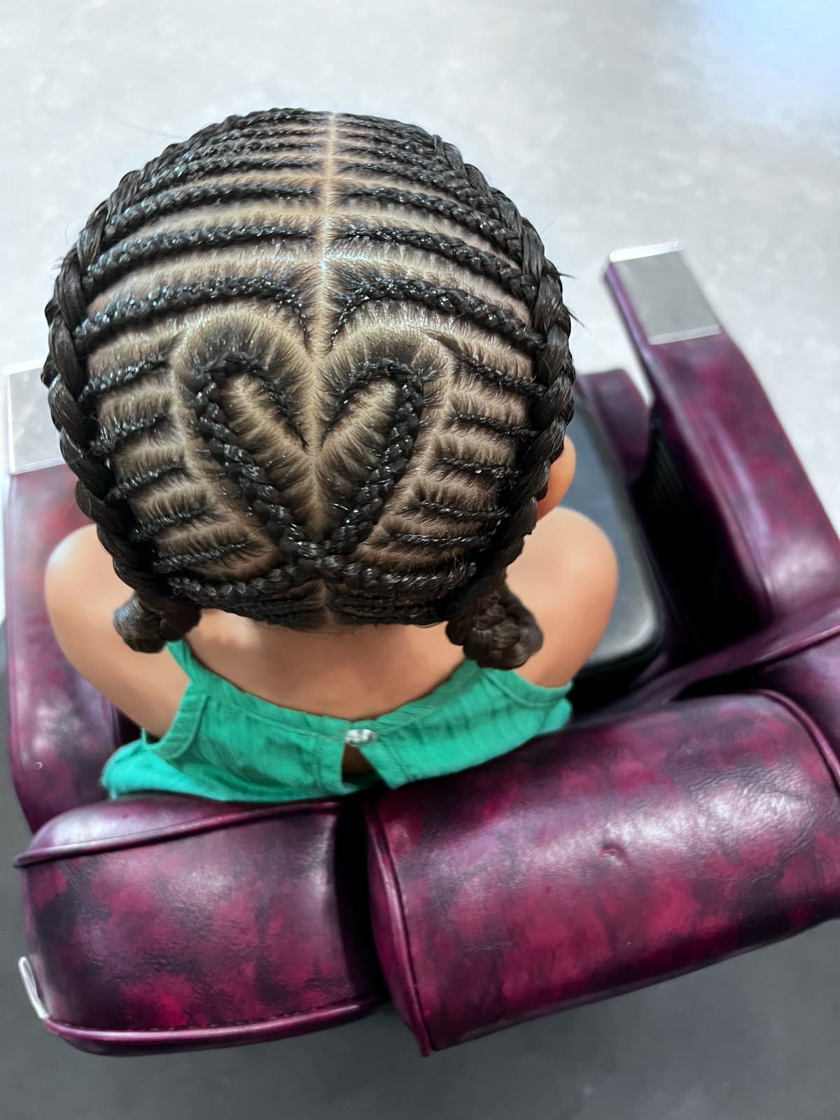 Heart-pattern cornrows on a young child, bird's-eye view
