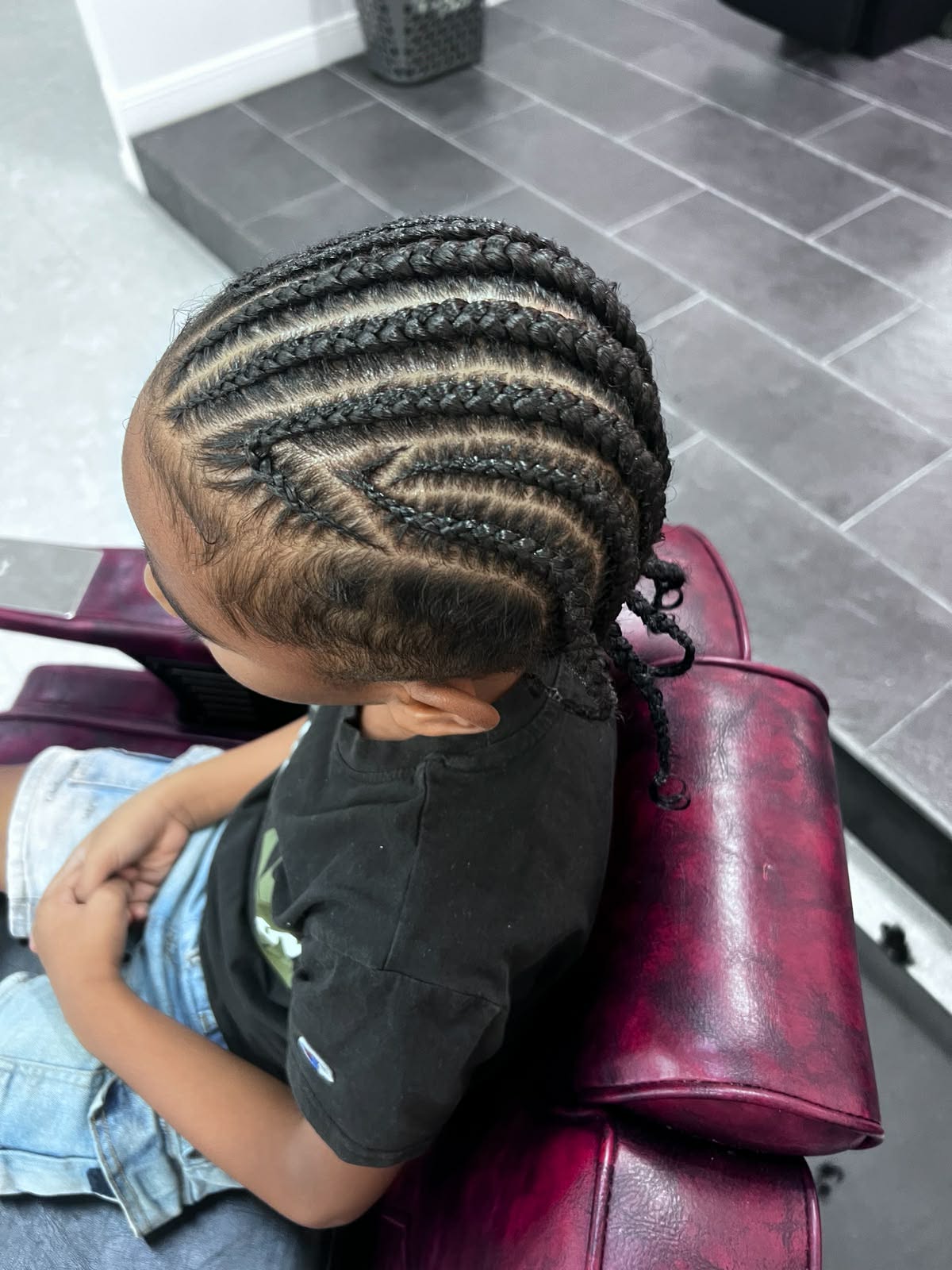 Curved feed-in cornrows on a young boy